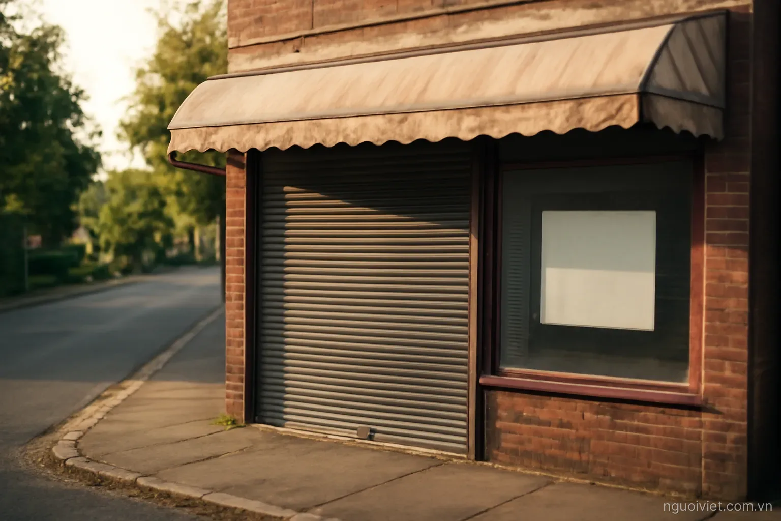a shuttered shopfront on a quiet suburban street with a faded awning in afternoon light