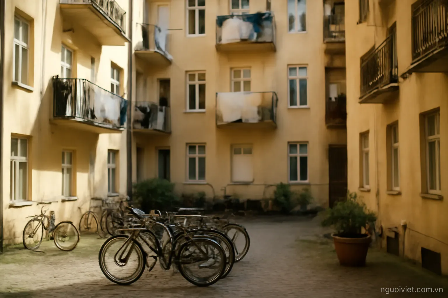 an apartment block courtyard in a European city with bicycles and washing on balconies